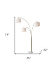 74" Brass Three Light Arc Floor Lamp With Off White Fabric Drum Shade