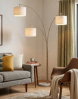 74" Brass Three Light Arc Floor Lamp With Off White Fabric Drum Shade